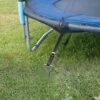 Hodzeed 4 Stück Bodenanker Set für Trampolin, Grassfläche mit sicher befestigtem Trampolin und schwarzem Gurt zur Verankerung.