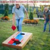 Zwei Männer spielen im Freien Cornhole mit bunten Säckchen auf einer grünen Wiese, ideal für gesellige Anlässe und Partys.
