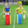 Ein fröhlicher Wettlauf von Kindern in bunten Kartoffelsack Renntaschen, die Spaß und Bewegung fördern. Ideal für Geburtstagsfeiern und Familienaktivitäten.