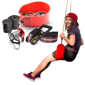 Person an einer Ninja Slider Seilrutsche im Freien, sitzend auf einem roten Sitz, umgeben von Kletterausrüstung, mit neutralem Hintergrund, der den Fokus auf das Outdoor-Abenteuer lenkt.