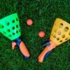 STUWU Riesen-XXL-Fangballspiel auf einer grünen Wiese, bestehend aus zwei bunten Fangbechern in leuchtendem Grün und Orange sowie zwei kleinen orangefarbenen Bällen. Perfekt für Spaß im Freien und Wasserspiele.