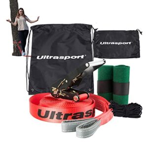 Eine rote 25m Slackline mit Ratsche und baumschutz, die zwischen zwei Bäumen gespannt ist. Im Hintergrund versucht eine Person, auf der Slackline das Gleichgewicht zu halten. Das Bild zeigt die Slackline-Ausrüstung für Anfänger und Familien im Freien.