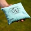 Hochwertiger, robuster hellblauer Stoffbeutel mit dem Aufdruck "WORLD CORNHOLE LEAGUE" und stilisierter Spieler-Darstellung, ideal für Cornhole-Spiele im Freien.